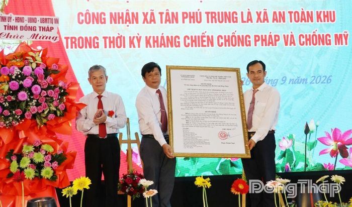 Đồng chí Đinh Văn Dũng, Phó Chủ tịch Thường trực Ủy ban MTTQ Việt Nam tỉnh Đồng Tháp (bên trái) trao Quyết định công nhận xã An toàn khu cho đại diện lãnh đạo xã Tân Phú Trung.