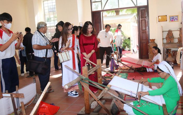 Học sinh và du khách xem các nghệ nhân biểu diễn nghề dệt truyền thống tại Trung tâm Trưng bày văn hóa Chăm