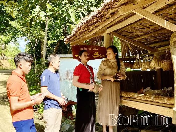 Bà Đinh Thị Yệu ở thôn Đức Phong, xã Tiền Phong (thứ 3 từ trái sang) giới thiệu mô hình “quán tự giác” - nét văn hóa độc đáo của người Mường Ạu Tá đến du khách.