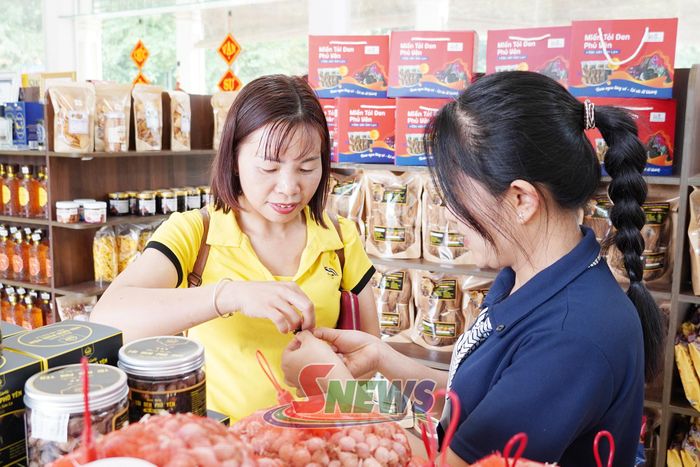 Du khách trải nghiêm sản phẩm Tỏi đen của HTX Sản xuất và kinh doanh tỏi Phù Yên. Ảnh: PV