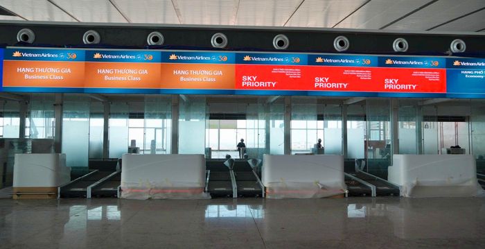 Tại khu vực quầy check-in, công nhân đang hoàn thiện những phần việc cuối cùng. Cách đó không xa là hệ thống quầy gửi hành lý tự phục vụ, một trong những điểm nhấn về công nghệ được dự kiến áp dụng tại sân bay Long Thành. Theo phương án vận hành, hành khách sẽ được tiếp cận nhiều công nghệ mới, trong đó có hình thức check-in bằng sinh trắc học, tự gửi hành lý và thực hiện một số thủ tục theo phương thức tự phục vụ.