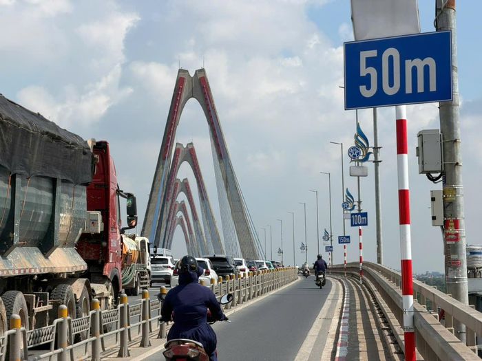 Phòng Cảnh sát giao thông, Công an TP Hà Nội phối hợp với Sở Xây dựng và các đơn vị liên quan lắp đặt hệ thống biển báo, vạch sơn xác định khoảng cách trên cầu Nhật Tân, giúp người điều khiển phương tiện chủ động giữ khoảng cách an toàn. Các mốc 0m, 50m, 100m, 150m và 200m được bố trí rõ ràng, dễ quan sát, hỗ trợ tài xế nhận biết khoảng cách với xe phía trước, điều chỉnh tốc độ và hạn chế nguy cơ va chạm liên hoàn.