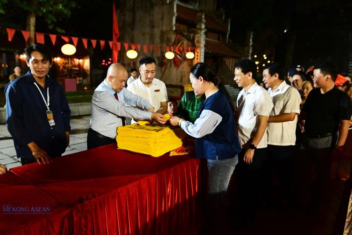 Ông Đỗ Thành Trung, Chủ tịch UBND thành phố Hải Phòng tặng ấn cho người dân. Ảnh: Anh Tín.