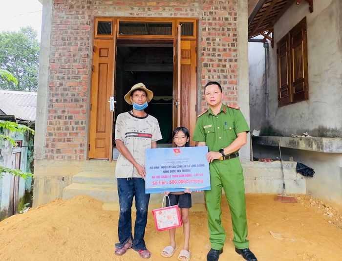 Anh Lê Văn Tia xúc động khi đón nhận món quà hỗ trợ thường xuyên từ cán bộ, chiến sĩ Công an xã Long Quảng.