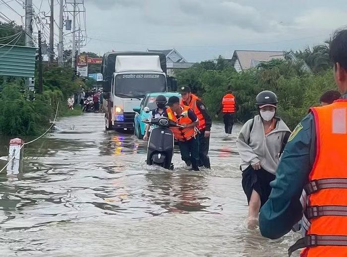 Lực lượng Công an hỗ trợ nhân dân di chuyển qua vùng ngập nước.