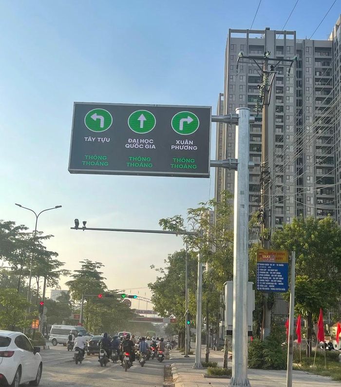 Bảng điện tử LED và hệ thống camera AI vận hành giao thông tại Hà Nội, cung cấp thông tin hướng dẫn hướng đi (Tây Tựu, Đại học Quốc gia, Xuân Phương) và trạng thái giao thông thời gian thực.