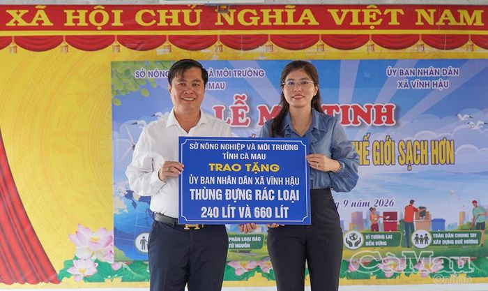 Bà Trịnh Khánh Ngọc, Chi cục trưởng Chi cục Bảo vệ Môi trường tỉnh Cà Mau (bìa phải) trao bảng tượng trưng cho ông Hứa Văn Quang, Phó Chủ tịch UBND xã Vĩnh Hậu, tặng 16 thùng chứa rác chuyên dụng cho bà con trên địa bàn.