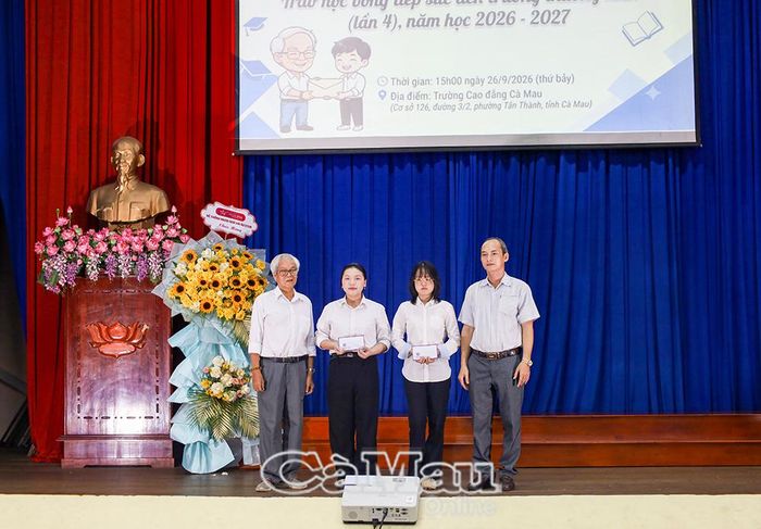 Thạc sĩ Huỳnh Thanh Hùng, Phó Hiệu trưởng Trường Cao đẳng Cà Mau (bìa phải) và nhà văn Nguyễn Đông Thức trao khen thưởng cho hai sinh viên có thành tích học tập xuất sắc.