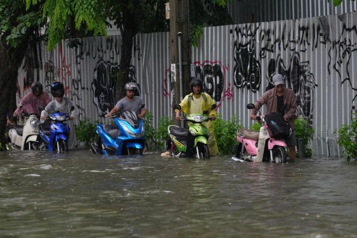 “Tôi thức dậy để đi làm và con đường trước nhà tôi đã bị ngập. Tôi lo lắng không biết xe máy của mình có thể đi qua vùng nước sâu này được không”, anh Samruay Nakkamnueng, người dân ở khu Ari nói. (Ảnh: AP)