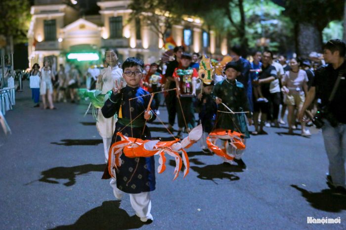 Các em nhỏ đang rước mẫu đèn lồng cặp cua sinh - tử. Con cua màu xanh là cua sống, màu đỏ là cua chín. Đây là một trong những mẫu đèn Trung thu truyền thống được phục dựng lại sớm nhất. Ảnh chụp của mẫu đèn này hiện được lưu giữ trong bảo tàng Quai Branly của Pháp.