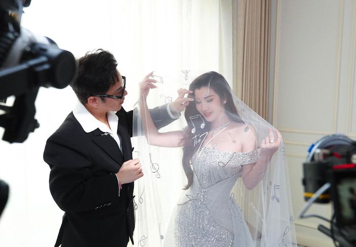 Trên lớp voan mỏng, Chung Thanh Phong đính Swarovski thành hình những nốt nhạc, thêu tên ca khúc "The Vow" - bản tình ca Châu Đăng Khoa viết lời để Akira Phan dành tặng vợ trong ngày cưới. Nhờ vậy, khăn voan không còn là phụ kiện che mặt cô dâu đơn thuần, mà trở thành kỷ vật mang thông điệp tỏ tình được chú rể gửi gắm khi hai người trở thành vợ chồng.