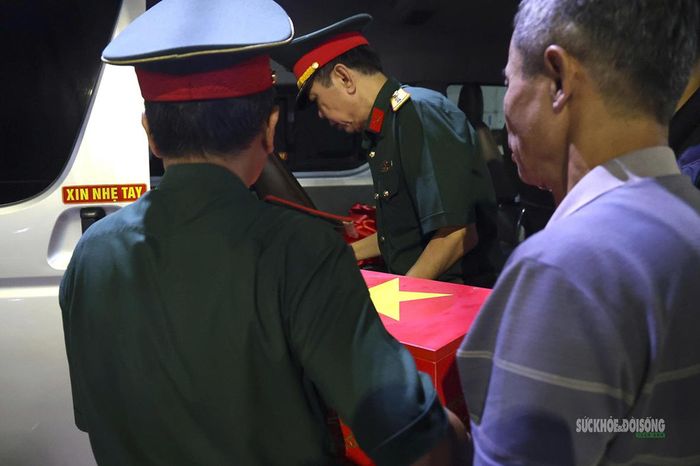 Hài cốt liệt sĩ được nâng niu trong những vòng tay trên hành trình trở về. Ảnh: Tuấn Anh