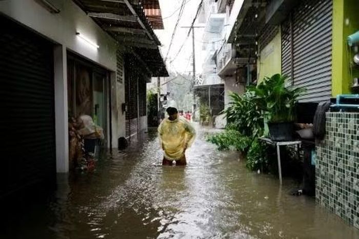 Nước ngập khiến người dân di chuyển khó khăn. Ảnh: AFP