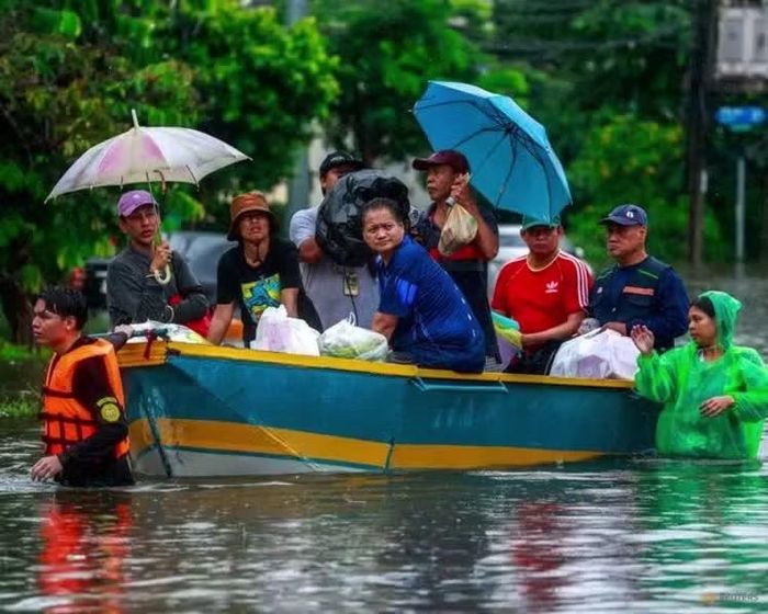 Người dân phải di chuyển bằng thuyền trên đoạn đường ngập nước ở Bangkok. Ảnh: Reuters