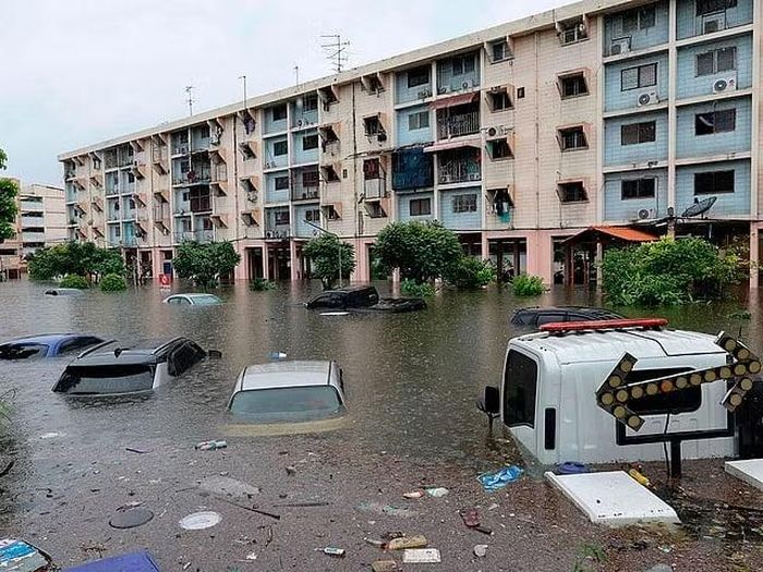 Ô tô đậu cạnh các tòa nhà dân cư bị nhấn chìm sau trận mưa lớn ở Bangkok