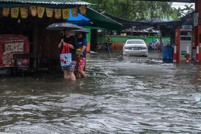  Người dân lội qua con đường ngập nước trong trận mưa lớn tại Bangkok, Thái Lan, ngày 26/9. Ảnh: Reuters. 
