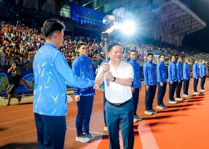 Bí thư Tỉnh ủy, Trưởng Đoàn ĐBQH tỉnh Nguyễn Khắc Thận tiếp nhận ngọn đuốc truyền thống từ vận động viên để thực hiện nghi thức thắp đài lửa Đại hội. Ảnh: Phương Thuý