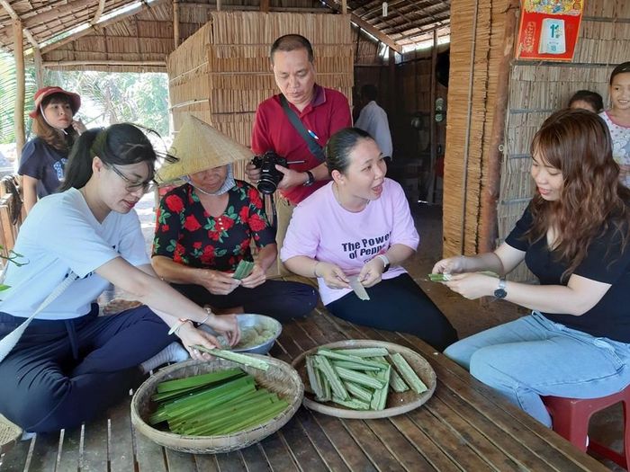 Du khách tự tay làm bánh lá dừa ở Khu du lịch cộng đồng Cồn Chim, tỉnh Vĩnh Long
