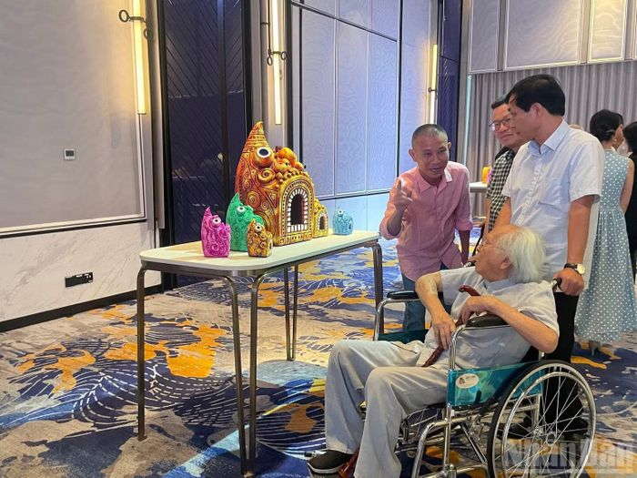 Nhà điêu khắc lão thành Tạ Quang Bạo (người ngồi xe lăn) đến tham quan triển lãm.