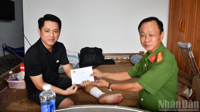 Đại tá Trà Quang Thanh, Phó Giám đốc Công an tỉnh Đồng Tháp trao kinh phí hỗ trợ cho Thượng úy Nguyễn Trần Hoàng An. (Ảnh: THANH VIỆT)