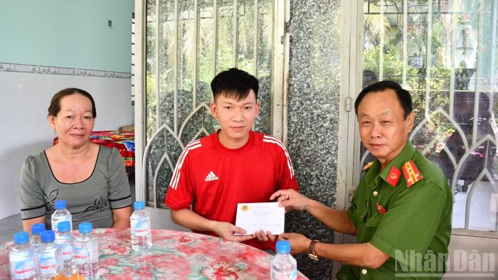 Đại tá Trà Quang Thanh, Phó Giám đốc Công an tỉnh Đồng Tháp trao kinh phí hỗ trợ cho đồng chí Hồ Xuân Hương. (Ảnh: THANH VIỆT)