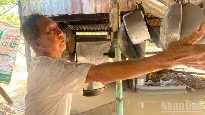 Gia đình ông Huỳnh Thanh Phương phải di chuyển các vật dụng trong nhà lên cao để tránh thiệt hại. (Ảnh: HOÀNG TRUNG)