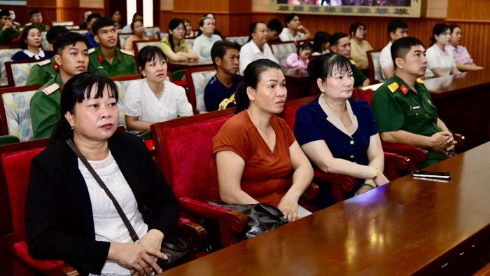 Thân nhân cán bộ, chiến sĩ Đội K74 chăm chú theo dõi phim về quá trình tìm kiếm, quy tập hài cốt liệt sĩ. (Ảnh: CTV)