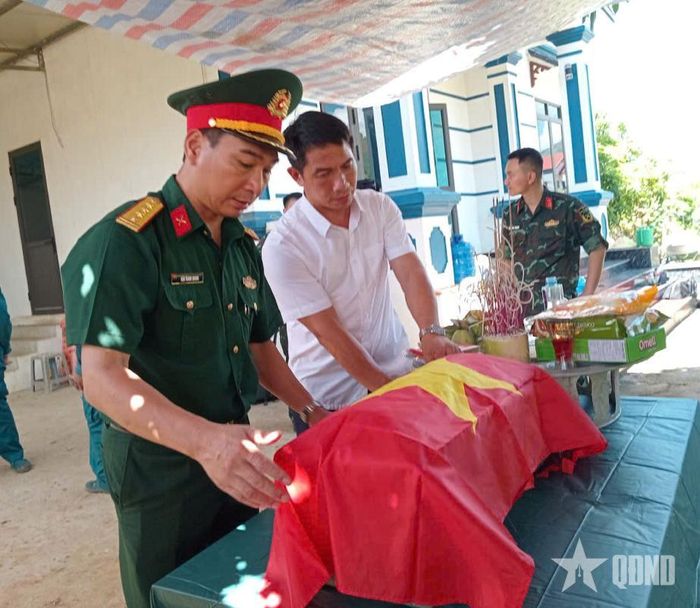  Đại tá Đậu Thanh Quang, Phó trưởng ban Thường trực Ban Chỉ đạo tỉnh, Chính ủy Bộ CHQS tỉnh Sơn La, thực hiện nghi thức phủ Quốc kỳ lên hài cốt được tìm thấy tại bản Cang Kiểng, xã Chiềng Khoong. 