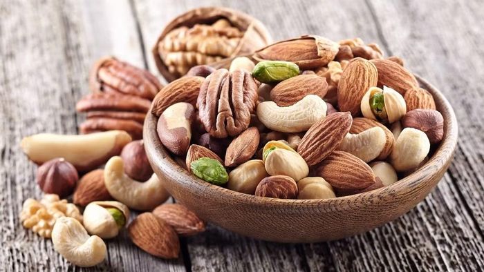 Hạnh nhân, óc chó, hạt điều, hạt mắc ca… cung cấp chất béo không bão hòa, protein và chất xơ. Một lượng nhỏ có thể dùng làm bữa phụ hoặc rắc lên sữa chua, yến mạch, salad. Vì các loại hạt có mật độ năng lượng cao, không nên ăn theo kiểu “càng nhiều càng tốt”; ưu tiên hạt nguyên chất, không tẩm đường hoặc chiên nhiều dầu. Ảnh: Điện máy XANH