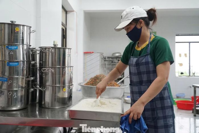 Nhân viên bếp chuẩn bị bữa ăn bán trú cho học sinh.