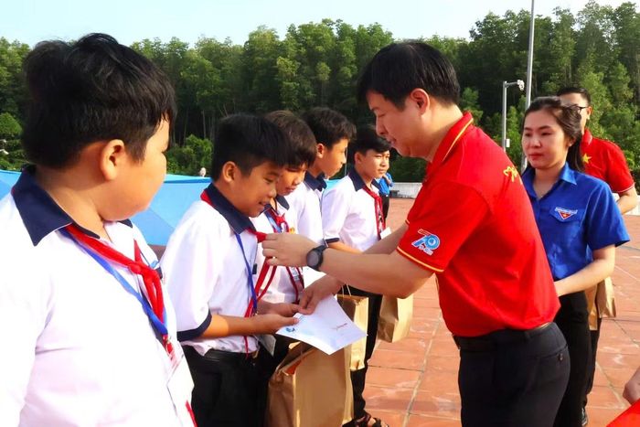Phó Chủ tịch Thường trực Trung ương Hội LHTN Việt Nam Lê Hải Long trao quà cho các em học sinh tại xã Đất Mũi.