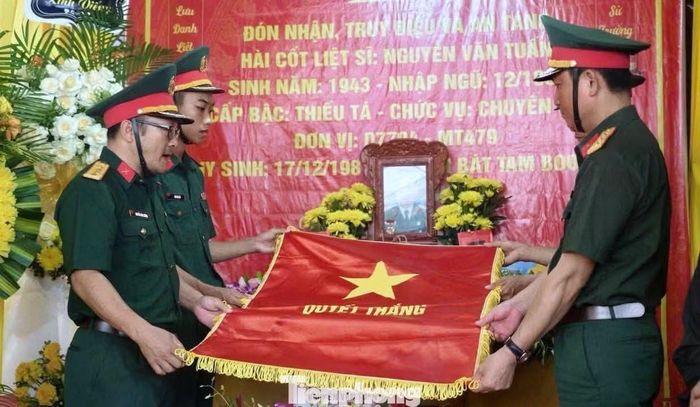Nghi thức phủ Quân kỳ trong lễ truy điệu liệt sĩ Nguyễn Văn Tuấn.