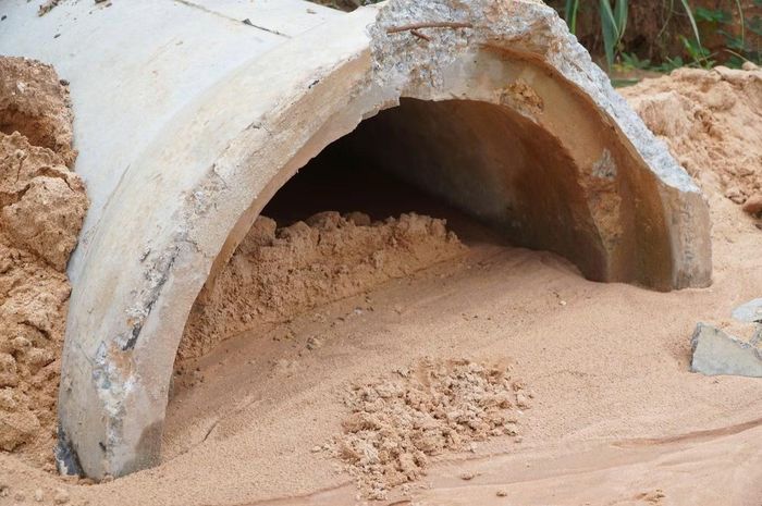 Lượng đất xói lở trên cao tốc Biên Hòa - Vũng Tàu lấp kín các ống cống thoát nước.