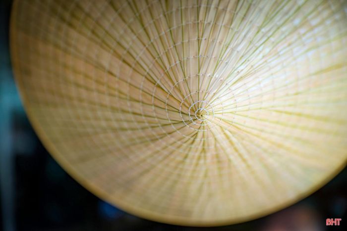 Mũi kim luồn qua lá, qua vành. Đường khâu cứ thế nối dài, chậm rãi mà chắc chắn, giữ cho chiếc nón bền đẹp qua nắng mưa.