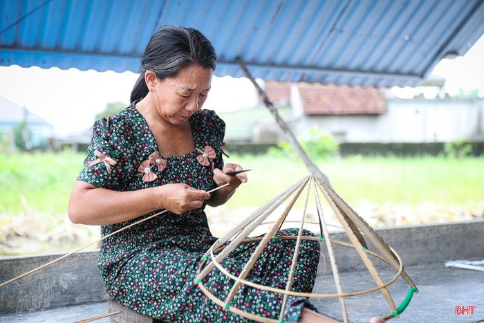 Từng lớp lá được xếp lên khuôn, ôm lấy những vòng vành. Bàn tay người thợ chỉnh từng mép lá để mặt nón phẳng và cân xứng.