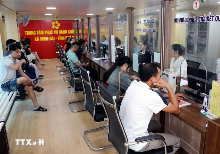 Cán bộ, công chức bộ phận Một cửa xã Minh Đài (Phú Thọ) tiếp nhận, hướng dẫn và xử lý hồ sơ hành chính cho người dân. (Ảnh: Tạ Toàn/TTXVN)