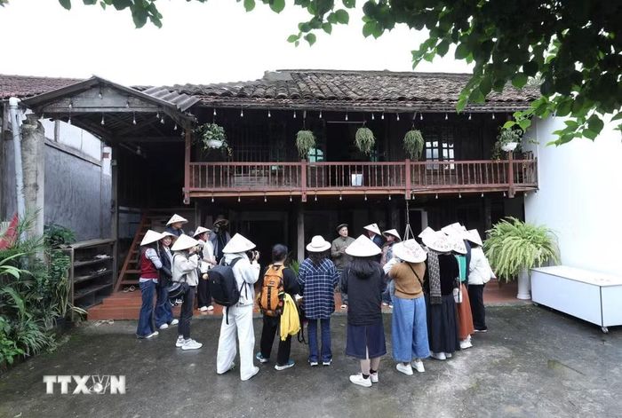 Du khách tìm hiểu về nhà sàn tại Làng du lịch cộng đồng Quỳnh Sơn, xã Bắc Sơn, tỉnh Lạng Sơn. (Ảnh: Anh Tuấn/TTXVN)