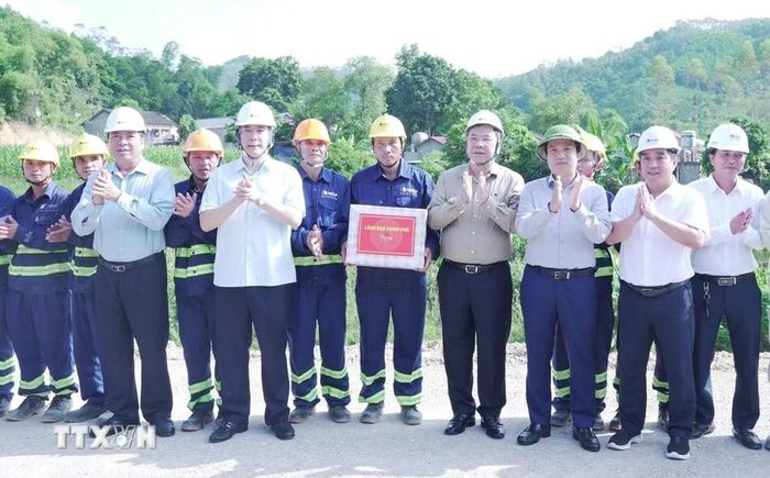 Phó Thủ tướng Thường trực Phạm Gia Túc cùng đại diện lãnh đạo Bộ Xây dựng và tỉnh Cao Bằng tặng quà động viên cán bộ, công nhân xây dựng tại công trường. (Ảnh: TTXVN phát)