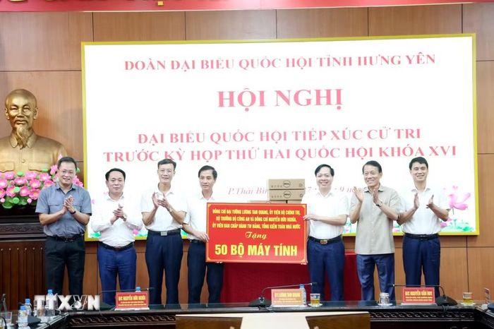 Đại tướng Lương Tam Quang, Ủy viên Bộ Chính trị, Bộ trưởng Bộ Công an cùng các đại biểu tặng máy tính hỗ trợ các địa phương. (Ảnh: Thế Duyệt/TTXVN)