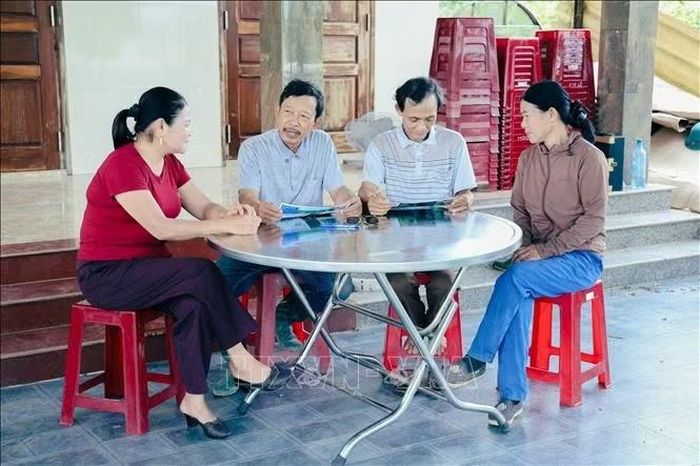 Ông Trần Đình Việt (thứ 2, trái sang) và ông Lê Văn Nam chia sẻ kinh nghiệm về quản lý, chăm sóc và bảo vệ rừng bền vững cho người dân địa phương. Ảnh: TTXVN phát