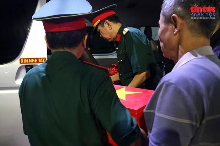 Nhẹ nhàng, cẩn trọng đưa hài cốt liệt sĩ lên xe về quê hương,