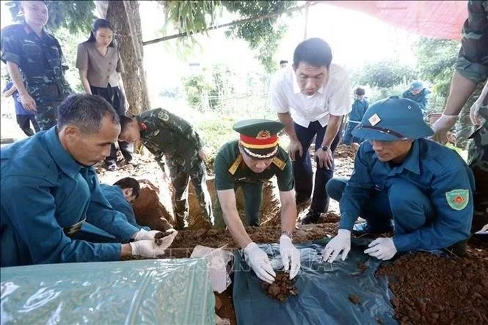 Lực lượng chức năng tham gia tìm kiếm, khai quật, cất bốc hài cốt liệt sĩ tại gia đình anh Đèo Văn Thiêm ở bản Cang Kiểng, xã Chiềng Khoong, tỉnh Sơn La.