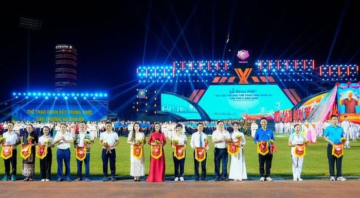 Ban Tổ chức trao cờ lưu niệm và hoa cho các đoàn vận động viên và các lực lượng về tham gia Đại hội TDTT tỉnh Nghệ An lần thứ X năm 2026. Ảnh PB. 