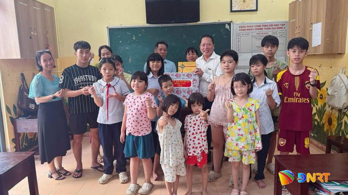 Chủ tịch UBND phường An Hải Hoàng Công Thanh (áo trắng, giữa) trao quà cho các em có hoàn cảnh khó khăn trên địa bàn phường. Ảnh: NHIÊN NGUYỄN