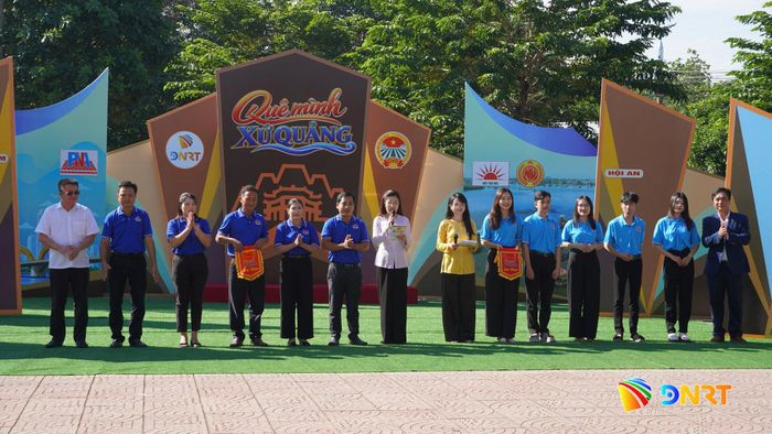 Hai đội chơi nhận cờ lưu niệm từ ban tổ chức chương trình. Ảnh: D.LỆ