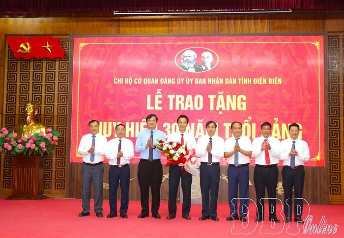 Các đồng chí trong Ban Thường vụ Đảng ủy UBND tỉnh tặng hoa chúc mừng đồng chí Lê Khánh Hòa.