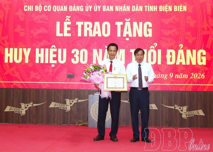 Đồng chí Lê Văn Lương, Phó Bí thư Tỉnh ủy, Bí thư Đảng ủy UBND tỉnh, Chủ tịch UBND tỉnh trao Huy hiệu 30 năm tuổi Đảng cho đồng chí Lê Khánh Hòa.