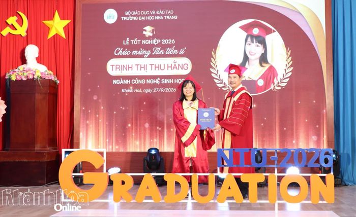 Lãnh đạo nhà trường trao bằng tốt nghiệp cho tân tiến sĩ.