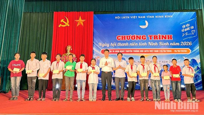 Ban Tổ chức và các đại biểu tặng quà cho các em học sinh có hoàn cảnh khó khăn trên địa bàn.