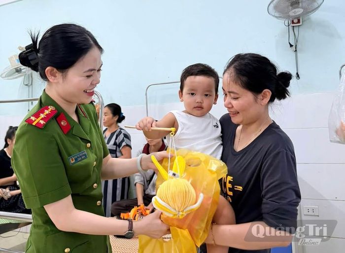 Cán bộ Công an xã Minh Hóa trao quà Trung thu, động viên bệnh nhi đang điều trị tại Bệnh viện đa khoa Minh Hóa - Ảnh: M.H